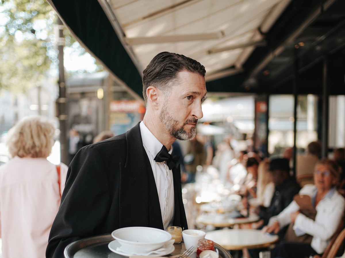 A professional server carrying a service tray